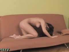 Симпатичная гимнастка показывает тело на диване