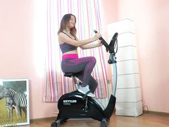 Сидя на шпагате спортивная гибкая девушка ласкает мокрую писю