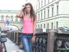 Стройная русская девушка в джинсах позирует на улице