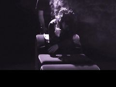 Курящая брюнетка позирует перед камерой и отдается парню