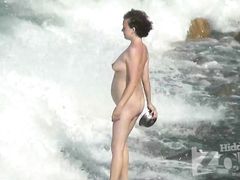 Беременная нудистка отдыхает на пляже не замечая видеонаблюдения