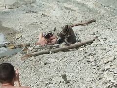 Отдыхающие нудисты на пляже не обращают внимание на камеру вуайериста