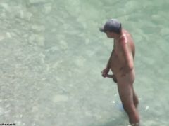 Вуайерист тайком наблюдает за мастурбирующим на пляже нудистом