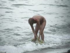 Стройная женщина купается в море голышом